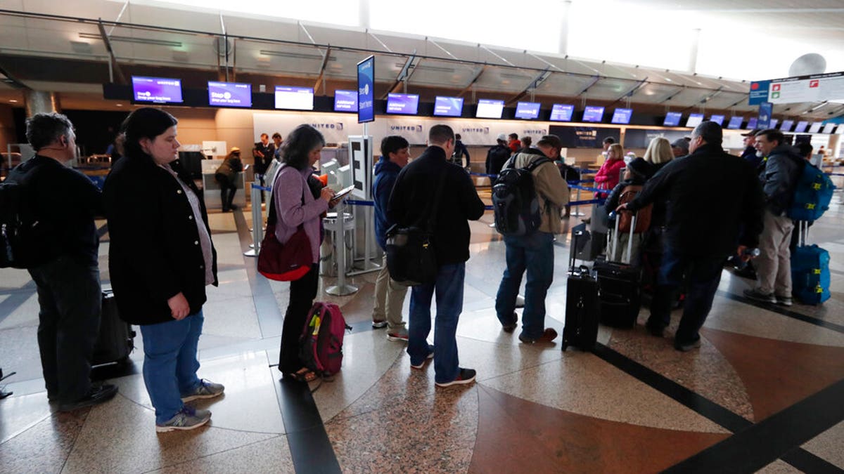 Passengers wait in a line to rebook their flights at the United Airlines counter in Denver International Airport Wednesday, April 10, 2019, in Denver. 