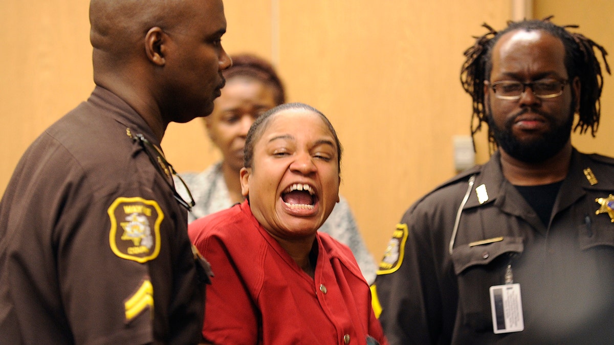 Mitchelle Blair is led out of the courtroom by Wayne County Sheriff deputies after an outburst during a custody hearing before Wayne County Circuit Judge Edward Joseph Thursday, June 4, 2015 in Detroit. She was arrested March 24 after court deputies carrying out an eviction at her apartment found the bodies of her children, Stoni Blair, 13, and Stephen Berry, 9, in a deep freezer.