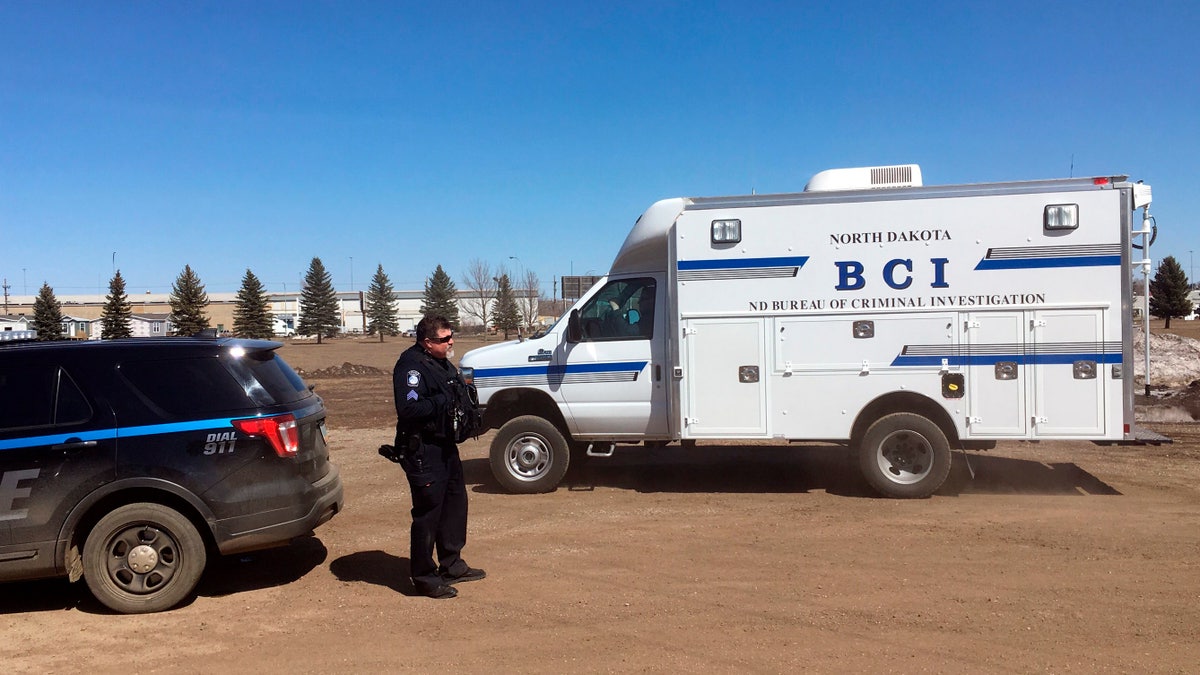 In this Wednesday, April 3, 2019 photo, state and local police search a field in Manton, N.D., about half a mile from a business where an owner and three employees were found dead. (Associated Press)