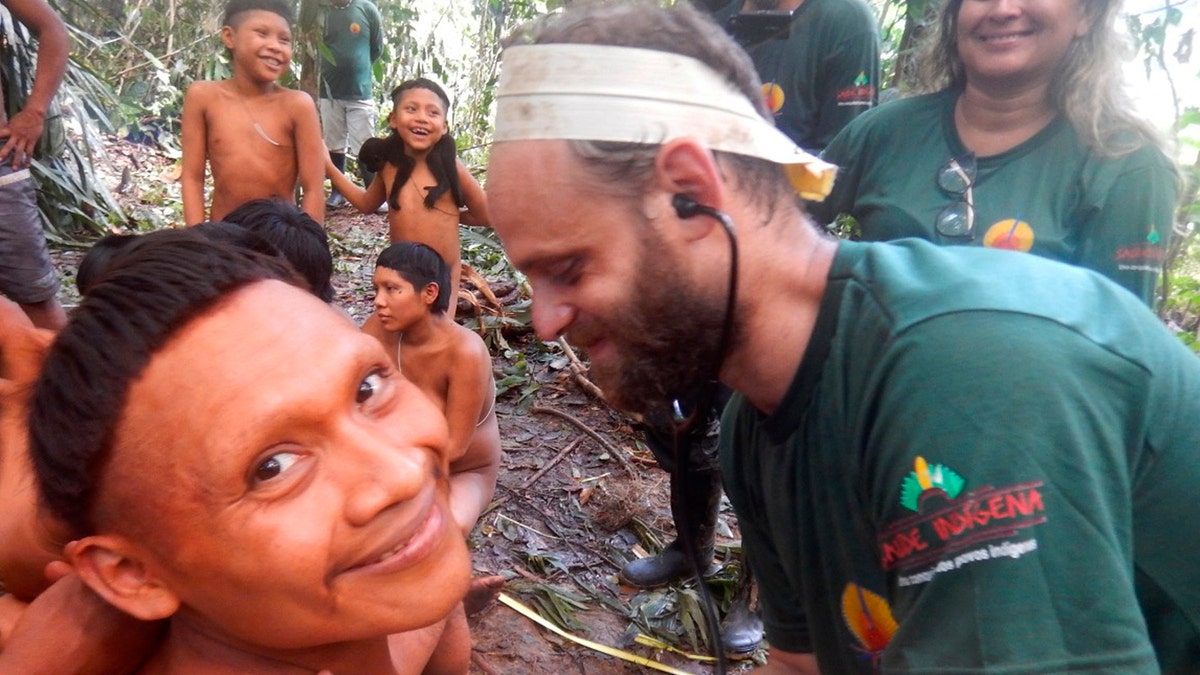 In this 2019 handout photo released by Brazil's National Indian Foundation, or FUNAI, a Korubo man smiled as a FUNAI member checked his heart rate during an expedition to the Javari Valley.