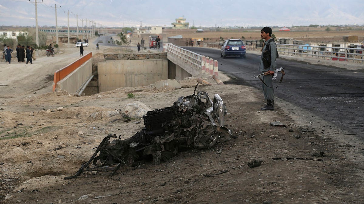 An Afghan security force stand guard at the site a day after an a suicide attack near the Bagram Air Base, north of Kabul, Afghanistan, Tuesday, April 9, 2019. Three American service members and a U.S. contractor were killed when their convoy hit a roadside bomb on Monday near the main U.S. base in Afghanistan, the U.S. forces said. The Taliban claimed responsibility for the attack. (AP Photo/Rahmat Gul)