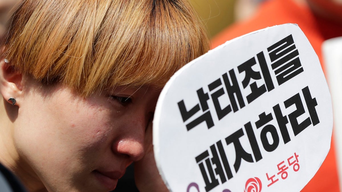 A woman wipes tears during a rally demanding the abolition of abortion law outside of the Constitutional Court in Seoul, South Korea on Thursday. (AP Photo/Lee Jin-man)