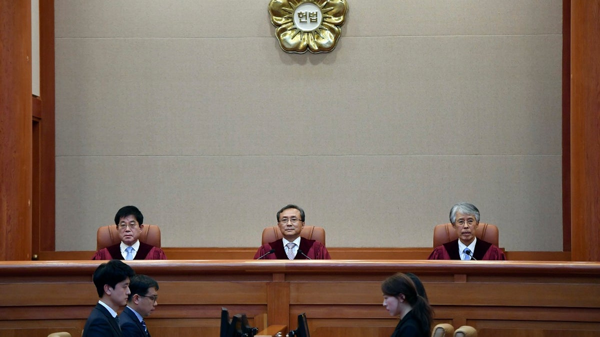 South Korea's Constitutional Court chief judge Yoo Nam-seok, center, and other judges sit for the ruling on decriminalization of abortion at the court in Seoul on Thursday. (Jung Yeon-je /Pool Photo via AP)