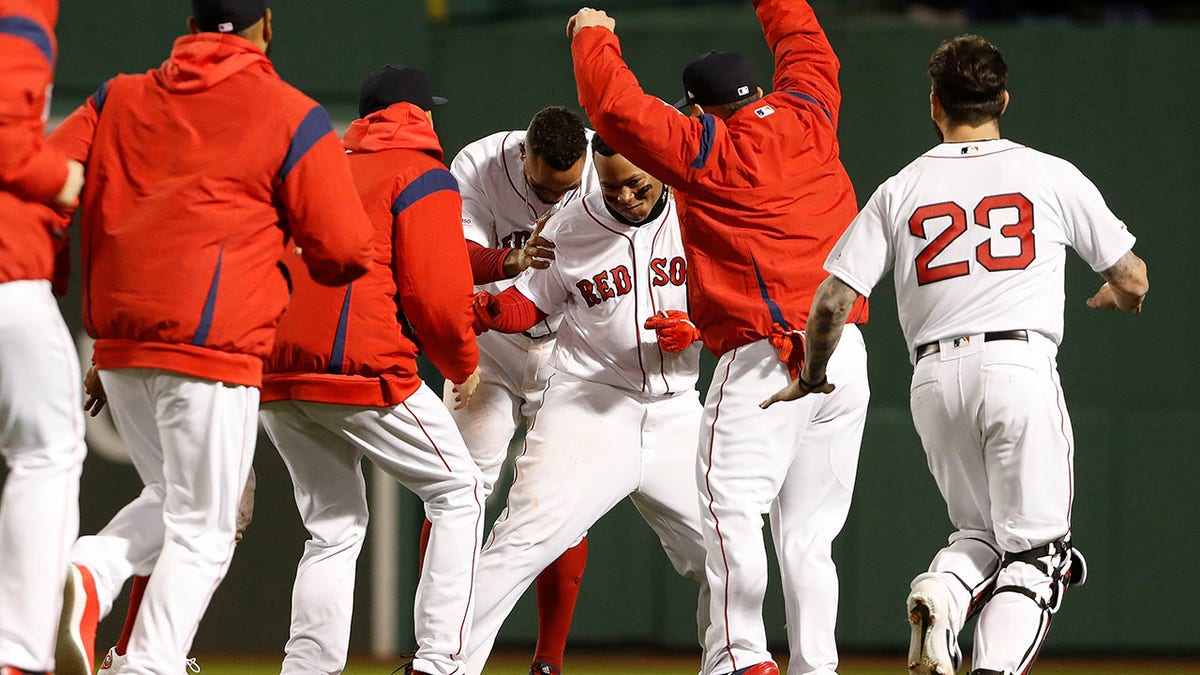 Boston Red Sox's Rafael Devers is congratulated by teammates after his walk-off single against the Toronto Blue Jays Thursday. 