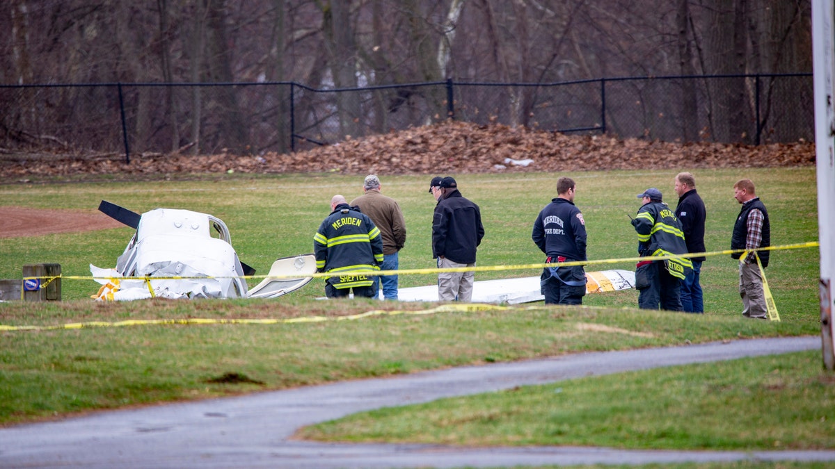 Emergency crews look over the wreckage Friday morning April 12, 2019 of a plane that crashed on the field at Wilcox Technical High School in Meriden Thursday night.