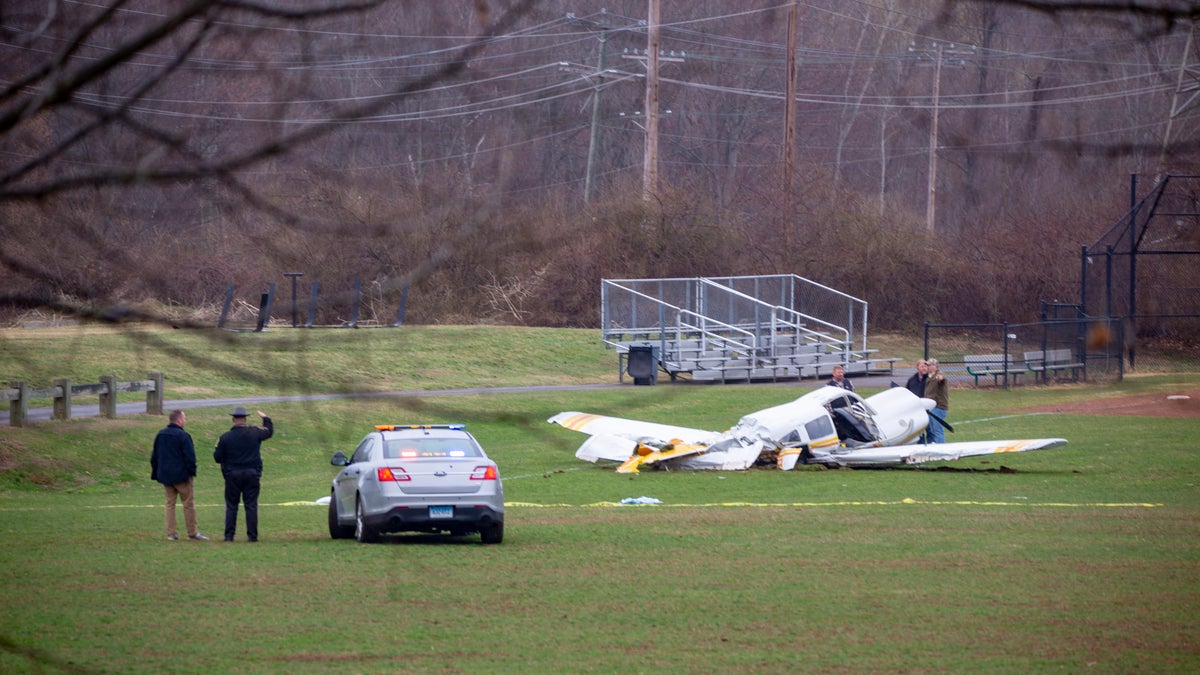 Emergency crews look over the wreckage Friday morning April 12, 2019 of a plane that crashed on the field at Wilcox Technical High School in Meriden Thursday night.