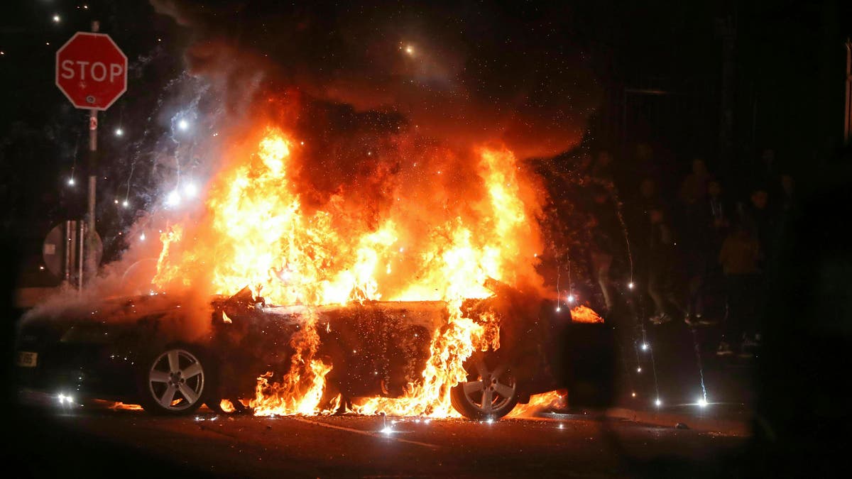 A journalist was shot to death during Northern Ireland rioting, Thursday, April 18, 2019. A car burns after petrol bombs were thrown at police in the Creggan area of Londonderry. 