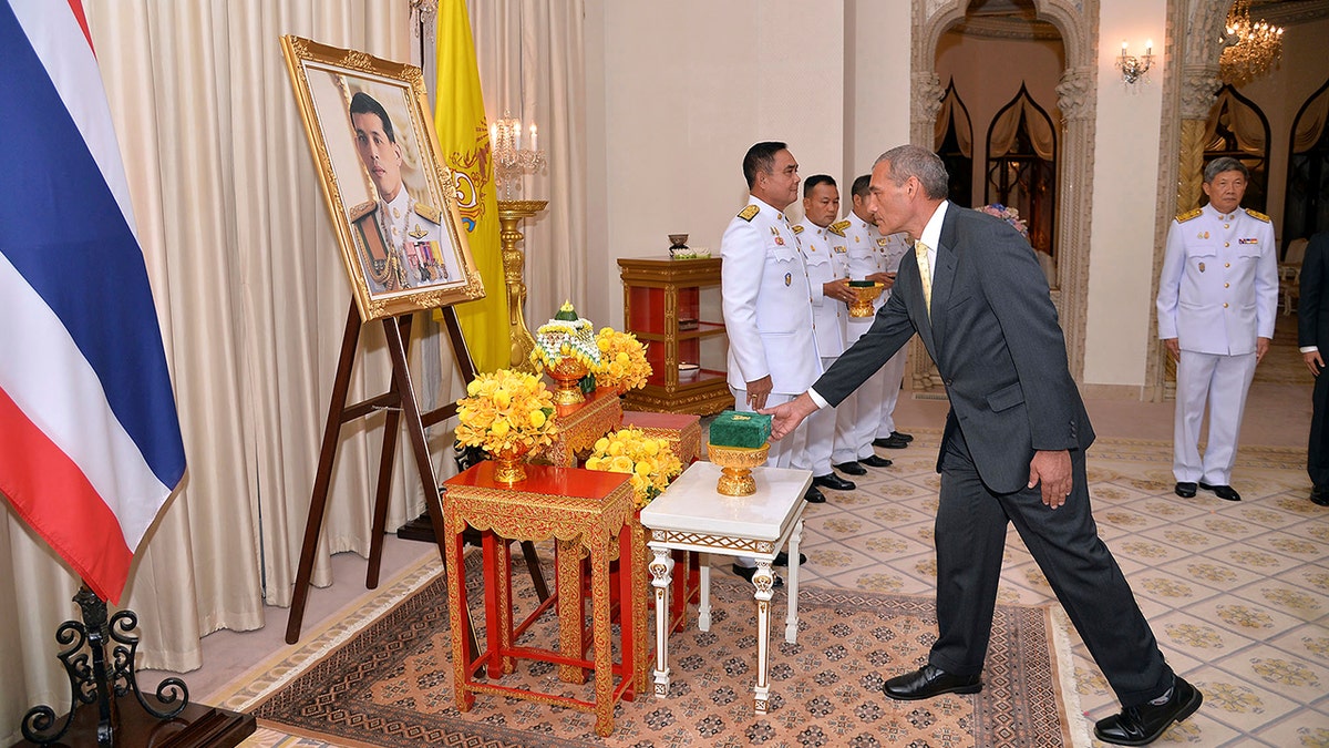 In this photo released by Government Spokesman Office, Craig Challen, an Australian member of the Thai cave rescue team, receives the Member of the Most Admirable Order of the Direkgunabhorn in front of a portrait of Thailand's King Maha Vajiralongkorn Bodindradebayavarangkun during the royal decoration ceremony at the Royal Thai Government House in Bangkok, Thailand, Friday, April 19, 2019.