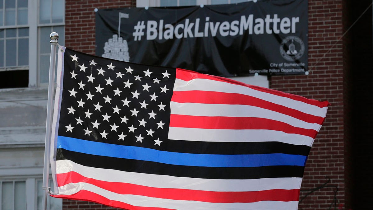 FILE - In this July 28, 2016, file photo, a flag with blue and black stripes in support of law enforcement officers, flies at a protest by police and their supporters outside Somerville City Hall in Somerville, Mass. (Associated Press)