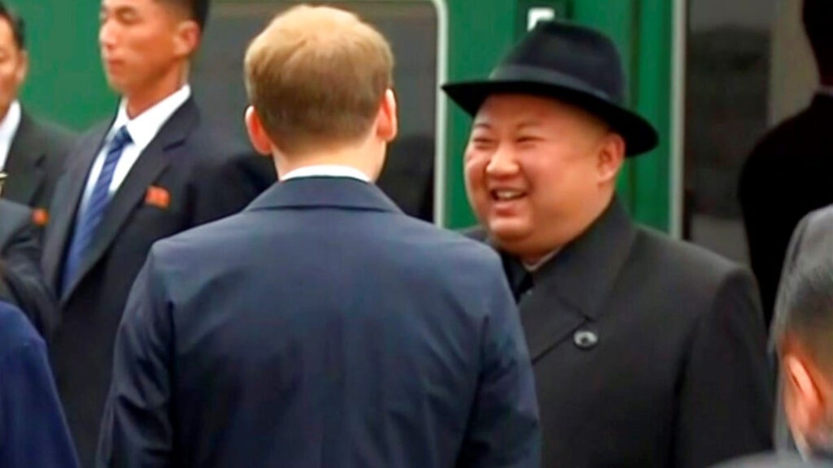 North Korean leader Kim Jong Un smiles as he leaves a train in Vladivostok railway station in Vladivostok, Russia.