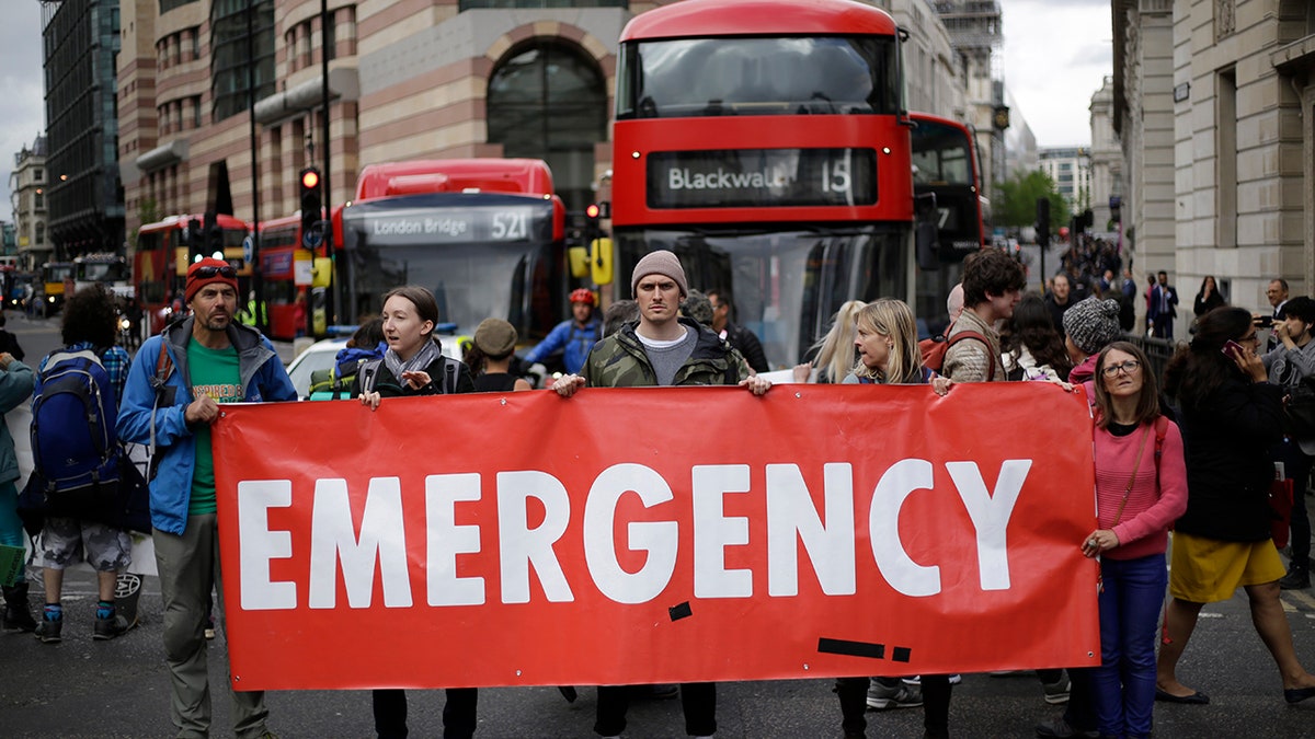 Extinction Rebellion climate change protesters briefly block the road in the City of London, Thursday, April 25, 2019. The non-violent protest group, Extinction Rebellion, is seeking negotiations with the government on its demand to make slowing climate change a top priority.