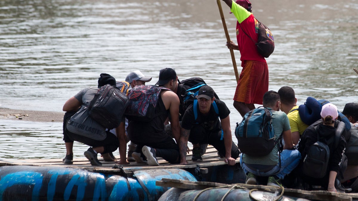 Migrants cross the border between Mexico and Guatemala, on a raft over the Suchiate river near Ciudad Hidalgo, Chiapas state, Mexico, Saturday, April 27, 2019. Thousands of migrants remain on the southern border of Mexico waiting for documents that allow them to stay legally in the country. (AP Photo/Moises Castillo)