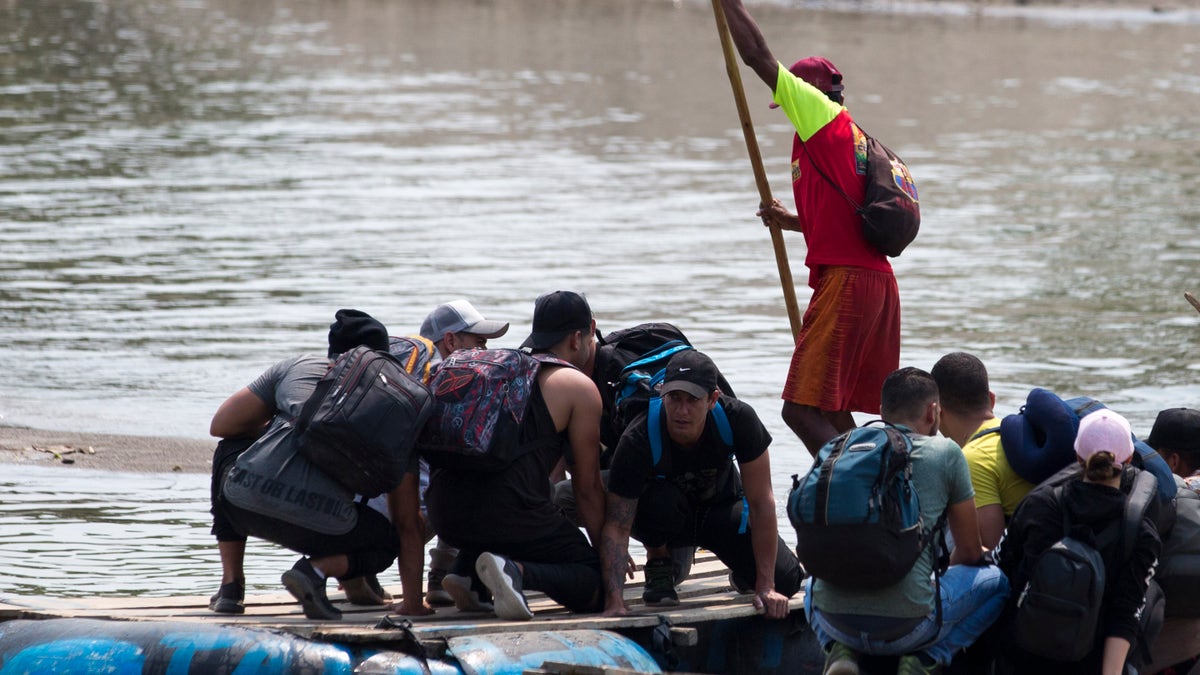 Migrants cross the border between Mexico and Guatemala, on a raft over the Suchiate river near Ciudad Hidalgo, Chiapas state, Mexico, Saturday, April 27, 2019. Thousands of migrants remain on the southern border of Mexico waiting for documents that allow them to stay legally in the country. (AP Photo/Moises Castillo)