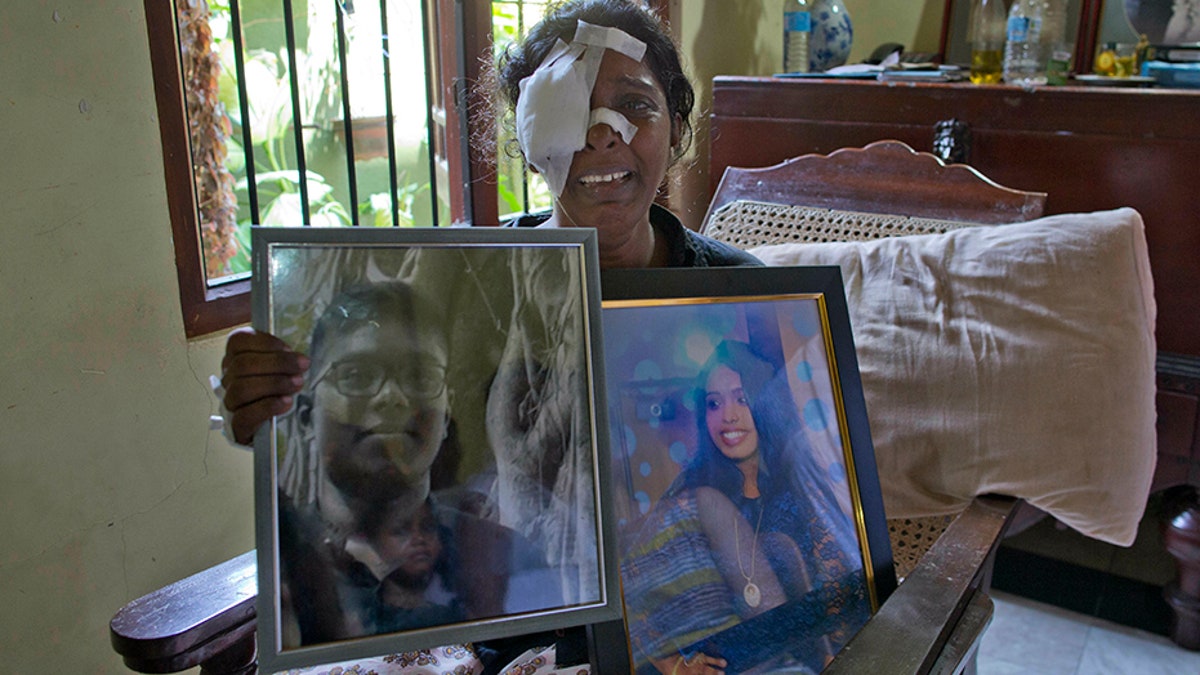 Anusha Kumari holds portraits of her daughter Sajini Venura Dulakshi and son Vimukthi Tharidu Appuhami, both victims of Easter Sunday's bomb blasts.