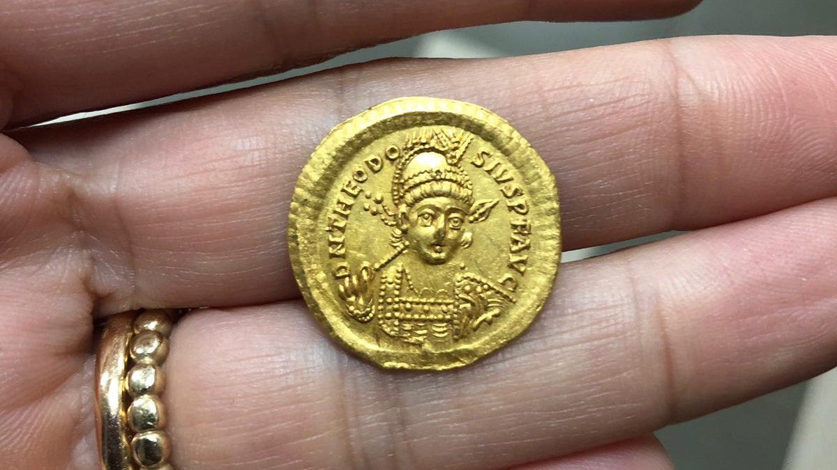 The coin, which bears the image of Byzantine Emperor Theodosius II. (Photograph Nir Distelfeld, Israel Antiquities Authority)
