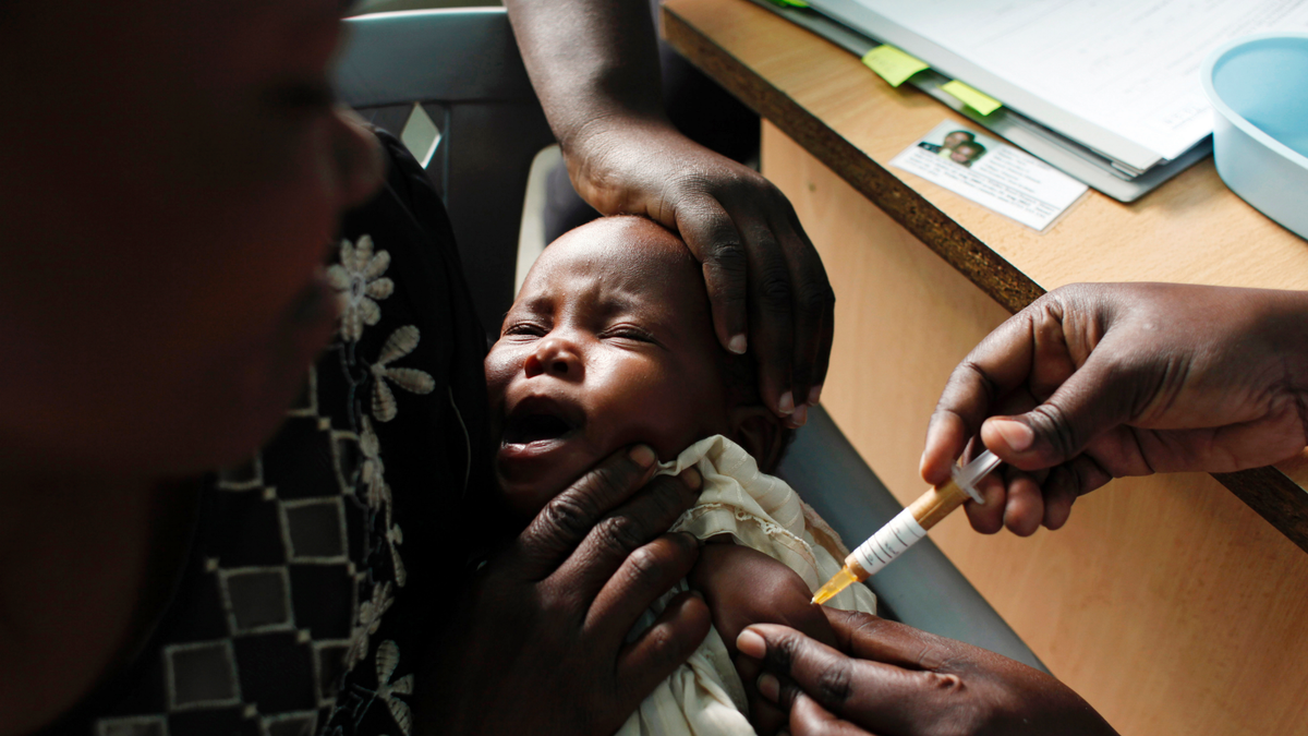 A mother holds her baby receiving a new malaria vaccine as part of a trial at the Walter Reed Project Research Center in Kombewa, Western Kenya, on Oct. 30, 2009.   (AP Photo/Karel Prinsloo, File)