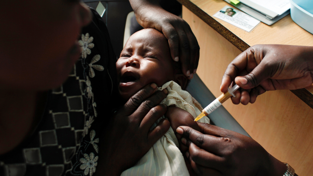 A mother holds her baby receiving a new malaria vaccine as part of a trial at the Walter Reed Project Research Center in Kombewa, Western Kenya, on Oct. 30, 2009. (AP Photo/Karel Prinsloo, File)