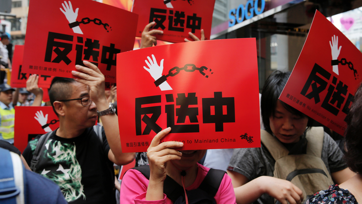 People raise placards reading " Against Extradition law" as thousands of protesters march along a downtown street against the extradition law in Hong Kong Sunday, April 28, 2019. (AP Photo/Vincent Yu)