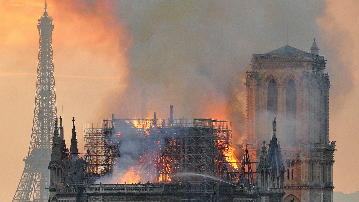 In this image made available on Tuesday April 16, 2019 flames and smoke rise from the blaze after the spire toppled over on Notre Dame cathedral in Paris, Monday, April 15, 2019.