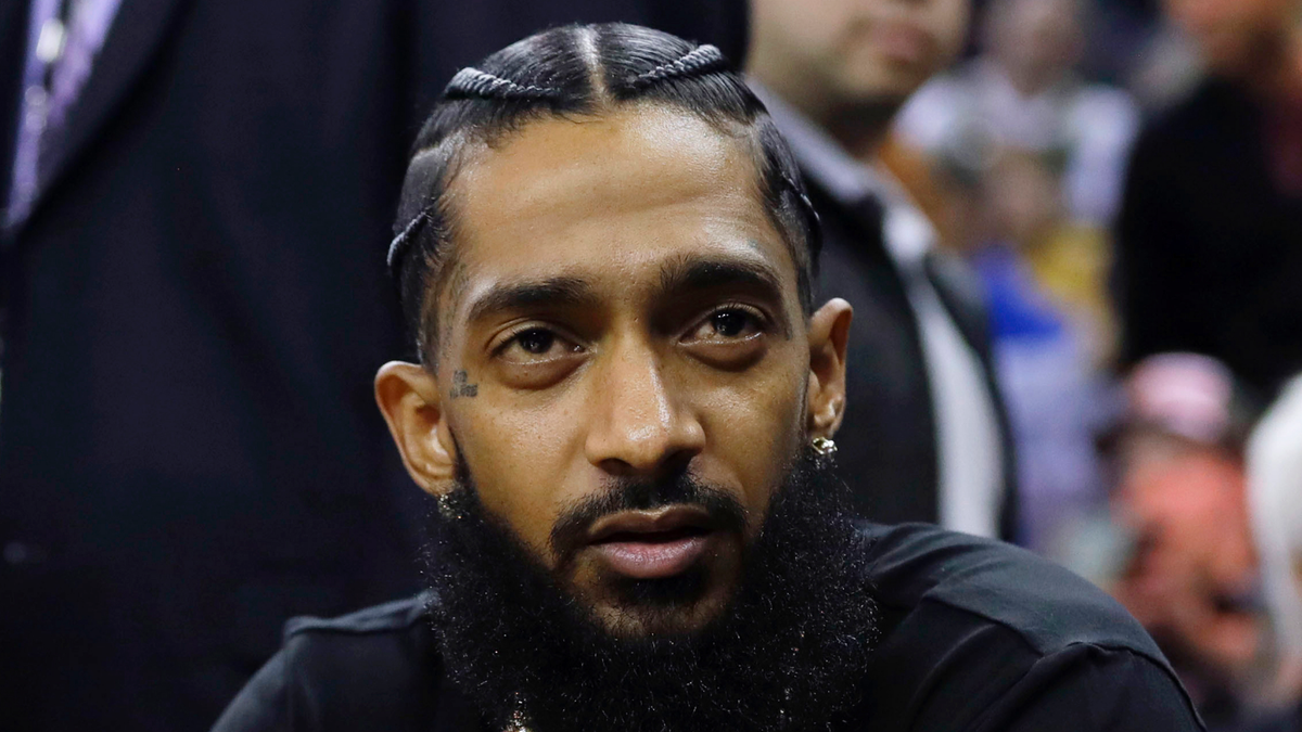 This March 29, 2018 file photo shows rapper Nipsey Hussle at an NBA basketball game between the Golden State Warriors and the Milwaukee Bucks in Oakland, Calif. Hussle was shot and killed Sunday, March 31, 2019 outside of his clothing store in Los Angeles.