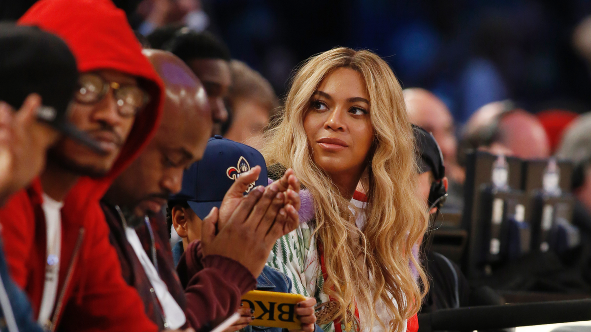 In this Feb. 19, 2017. file photo, Beyonce sits at court side during the second half of the NBA All-Star basketball game in New Orleans. Netflix on Sunday, April 7, 2019 posted on its social media channels a yellow image with the word “Homecoming” across it. The only other information was a date: April 17. That’s when Netflix is expected to premiere a Beyonce special that may feature her performances at last year’s Coachella Valley Music and Arts Festival. 
