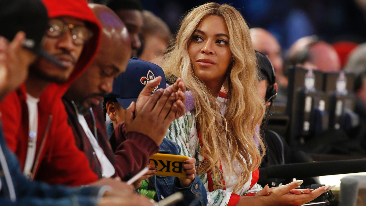 In this Feb. 19, 2017. file photo, Beyonce sits at court side during the second half of the NBA All-Star basketball game in New Orleans. Netflix on Sunday, April 7, 2019 posted on its social media channels a yellow image with the word “Homecoming” across it. The only other information was a date: April 17. That’s when Netflix is expected to premiere a Beyonce special that may feature her performances at last year’s Coachella Valley Music and Arts Festival.