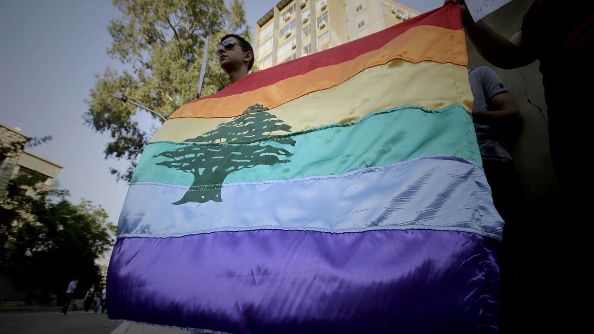 A gay pride flag bearing the cedar tree in the middle of it is carried by human rights activists during an anti-homophobia rally in Beirut on April 30, 2013. Top Lebanese military prosecutors acquitted four military personnel Saturday in a landmark ruling that affirms homosexuality is not a crime.
