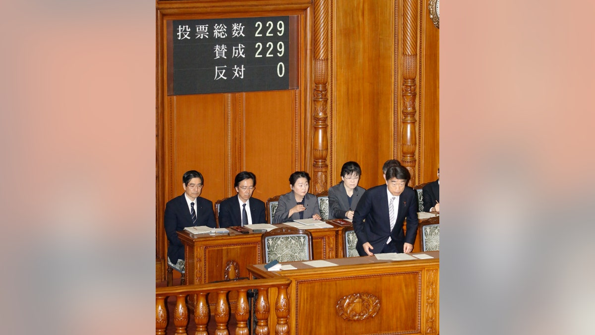Health, Welfare and Labor Minister Takumi Nemoto, right, bows after Eugenics Protection Law was passed at parliament's upper house in Tokyo Wednesday, April 25, 2019.
