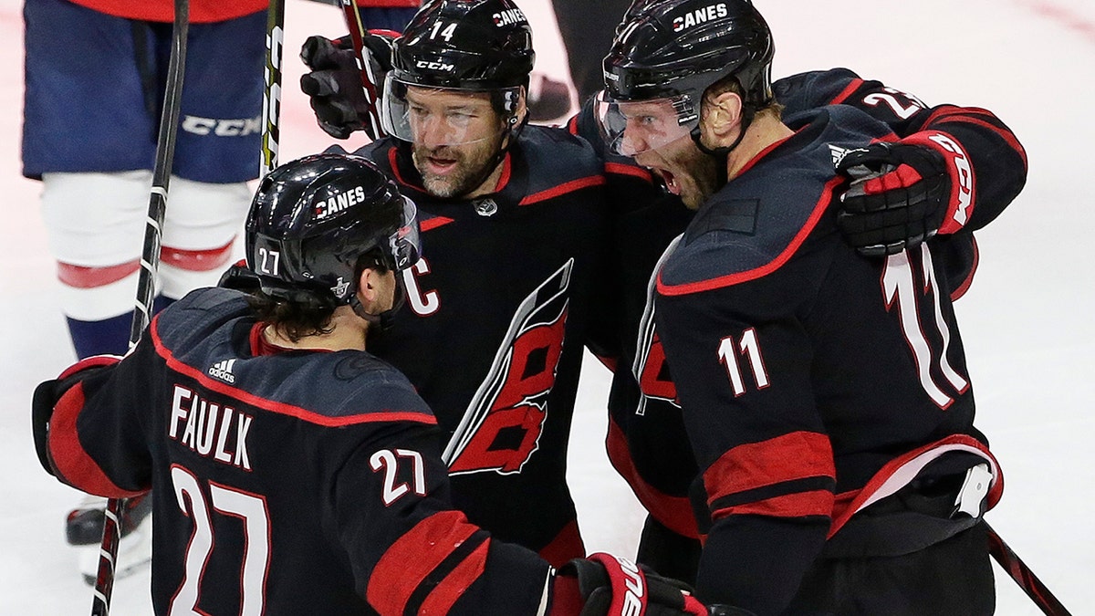 Carolina Hurricanes' Jordan Staal (11), Justin Faulk (27) and Justin Williams (14) celebrate Staal's goal against the Washington Capitals during the third period of Game 6 of an NHL hockey first-round playoff series in Raleigh, N.C., Monday, April 22, 2019. (AP Photo/Gerry Broome)