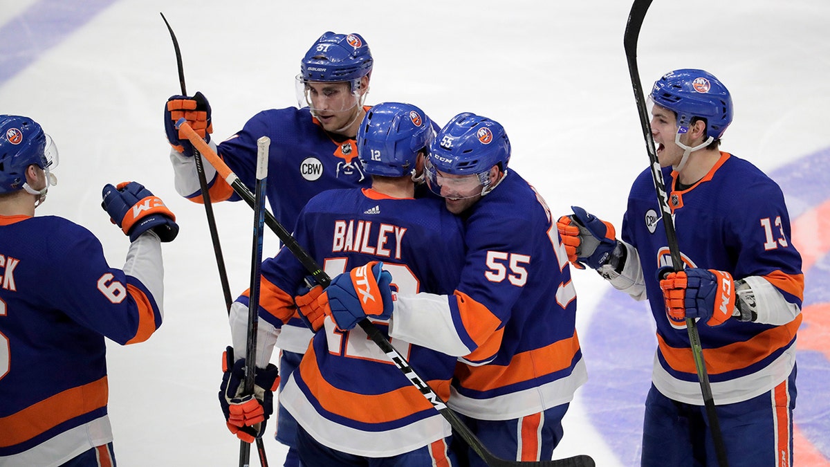 New York Islanders right wing Josh Bailey is hugged by defenseman Johnny Boychuk (55) as teammates celebrate after Bailey scored in overtime against the Pittsburgh Penguins during Game 1 of an NHL hockey first-round playoff series, Wednesday, April 10, 2019, in Uniondale, N.Y. The Islanders won 4-3. (AP Photo/Julio Cortez)