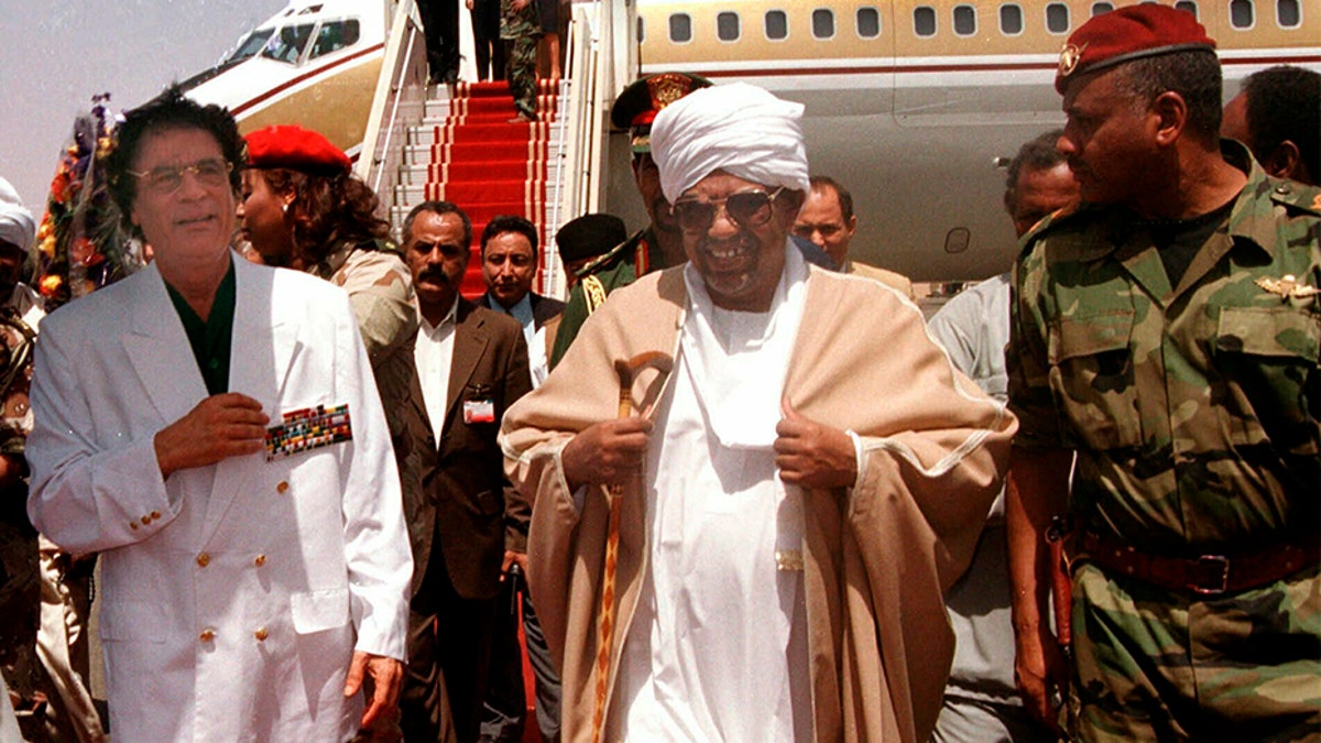 Former Libyan leader Muammar Qaddafi, left, is greeted by President Omar El-Bashir, center, upon his arrival in Khartoum for a two-day visit to Sudan, in 2001.