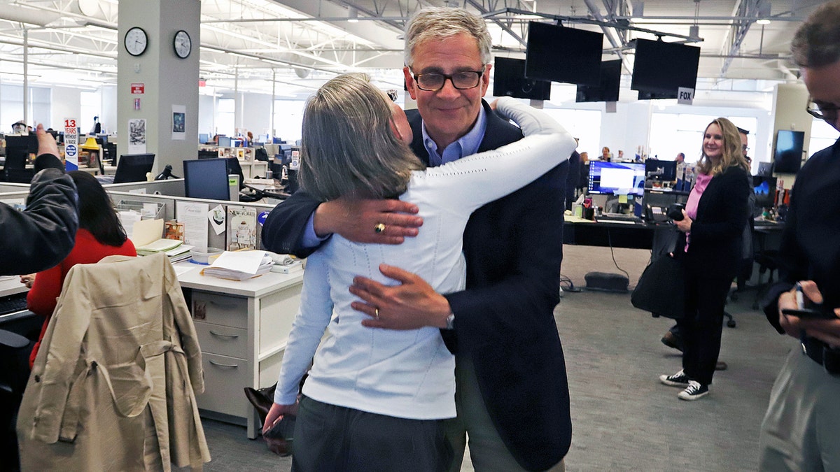 Pittsburgh Post Gazette retired Executive Editor David Shribman, center right, hugs city editor Lillian Thomas after the paper was awarded the Pulitzer Prize for Breaking News Reporting. (AP Photo/Gene J. Puskar)