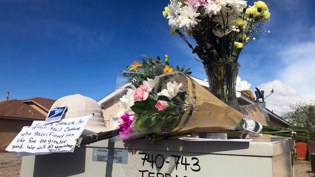 Flowers and notes are arranged atop a mailbox on April 23, 2019, in tribute to a mail carrier who police say was killed outside an adjacent home in Albuquerque, N.M. (Associated Press)