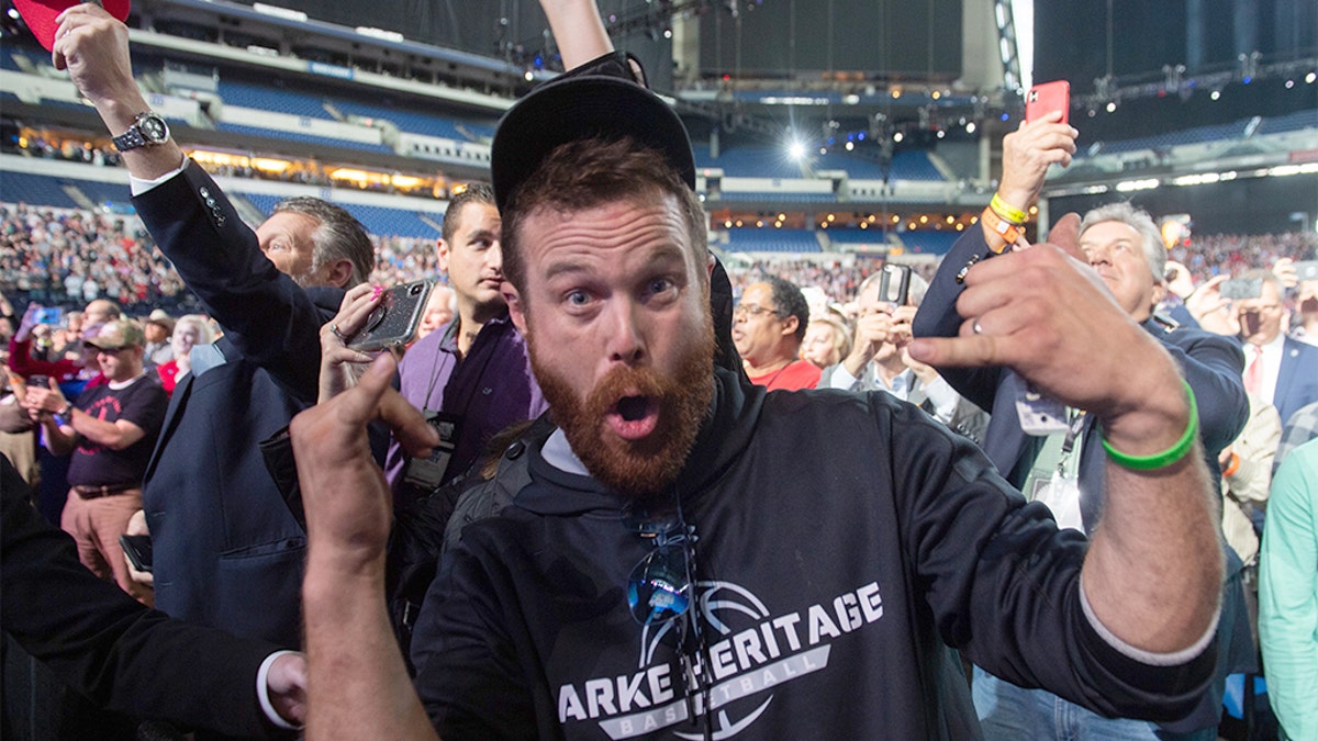 A man gestures towards the press corps after throwing an object on stage towards US President Donald Trump as he is speaking at the National Rifle Association (NRA) Annual Meeting at Lucas Oil Stadium in Indianapolis, Indiana, April 26, 2019. - The man was later removed from the scene by Secret service agents. (Photo by SAUL LOEB / AFP) (Photo credit should read SAUL LOEB/AFP/Getty Images)