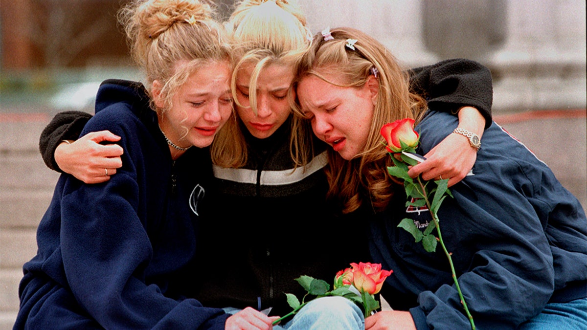 In this April 1999 file photo, Rachel Ruth, Rhianna Cheek and Mandi Annibel, all 16-year-old sophomores at Heritage High School in Littleton, Colo., console each other during a vigil service to honor the victims of the shooting spree in Columbine High School. (Associated Press)