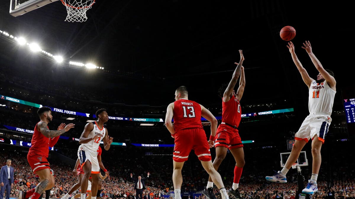 Virginia's Ty Jerome (11) makes a shot against Texas Tech's Kyler Edwards (0) during the second half in the championship of the Final Four NCAA college basketball tournament, Monday, April 8, 2019, in Minneapolis.