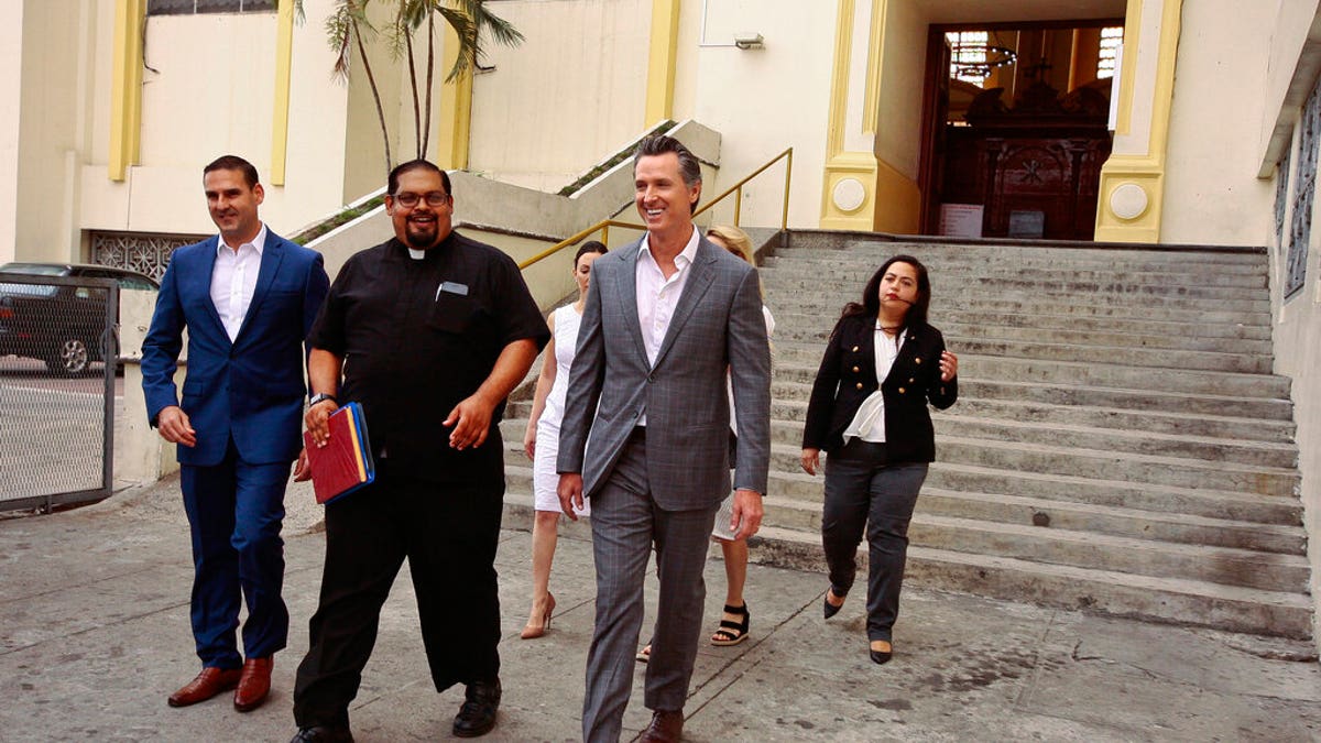 California Gov. Gavin Newsom, second from right, walks out with San Salvador Mayor Ernesto Muyshondtof, far left, after they visited the tomb of Archbishop Oscar Romero at Metropolitan Cathedral in San Salvador, El Salvador.