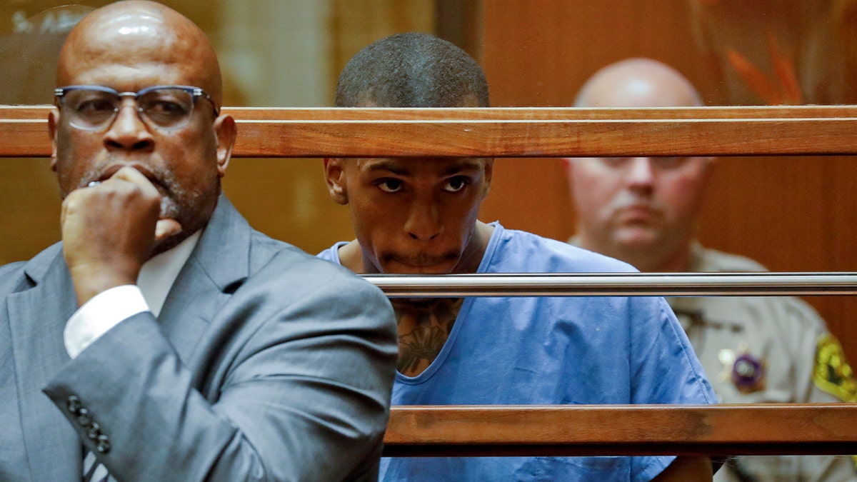 Eric Holder, the suspect in the killing of rapper Nipsey Hussle, is seen in Los Angeles County Superior Court with his attorney Christopher Darden, left, on Thursday. (Associated Press)