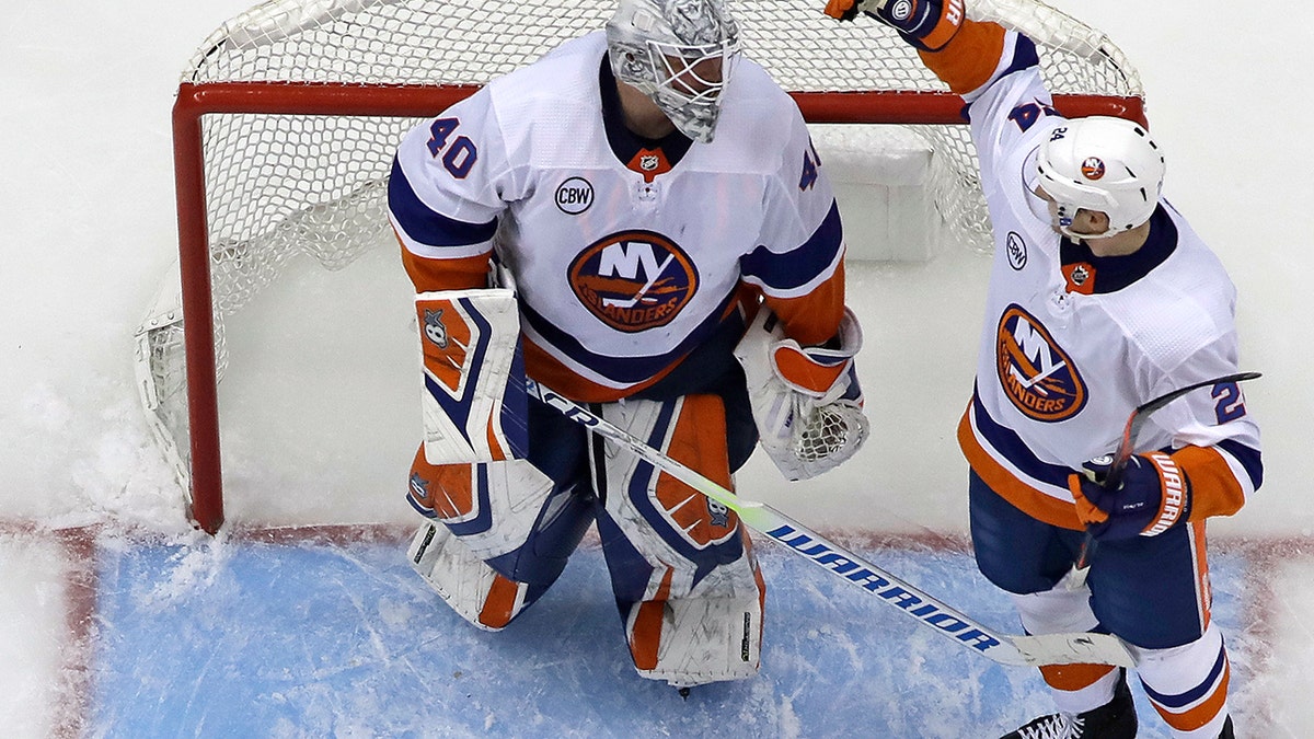 New York Islanders goaltender Robin Lehner, left, celebrates with Scott Mayfield (24) after a win over the Pittsburgh Penguins in Game 3 of an NHL first-round hockey playoff series in Pittsburgh, Sunday, April 14, 2019. (AP Photo/Gene J. Puskar)