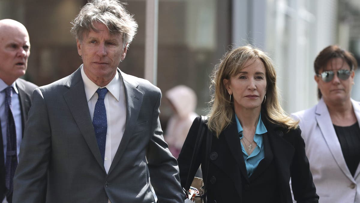 Actress Felicity Huffman arrives holding hands with her brother Moore Huffman Jr., left, at federal court in Boston on Wednesday, April 3, 2019, to face charges in a nationwide college admissions bribery scandal. (AP Photo/Charles Krupa)