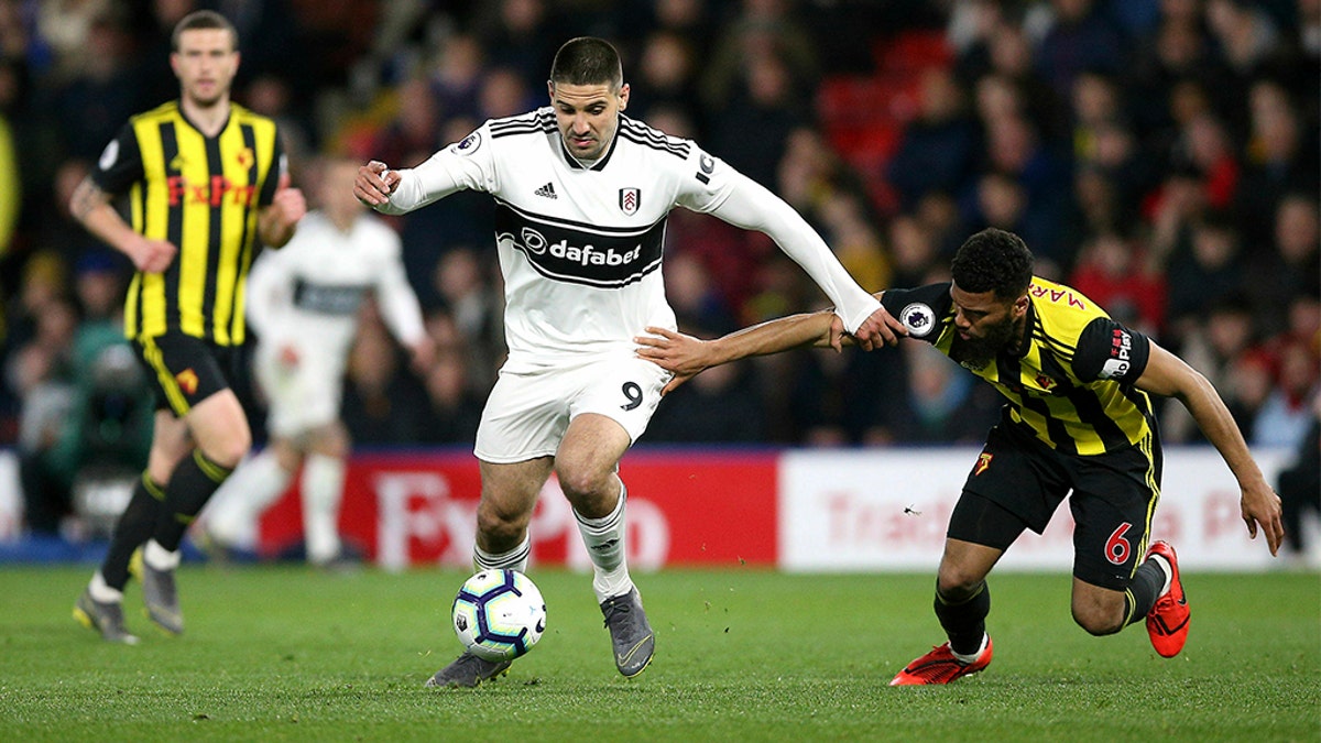 Fulham's Aleksandar Mitrovic, center, and Watford's Adrian Mariappa battle for the ball during their English Premier League soccer match at Vicarage Road, Watford, England, Tuesday, April 2, 2019. (Nigel French/PA via AP)