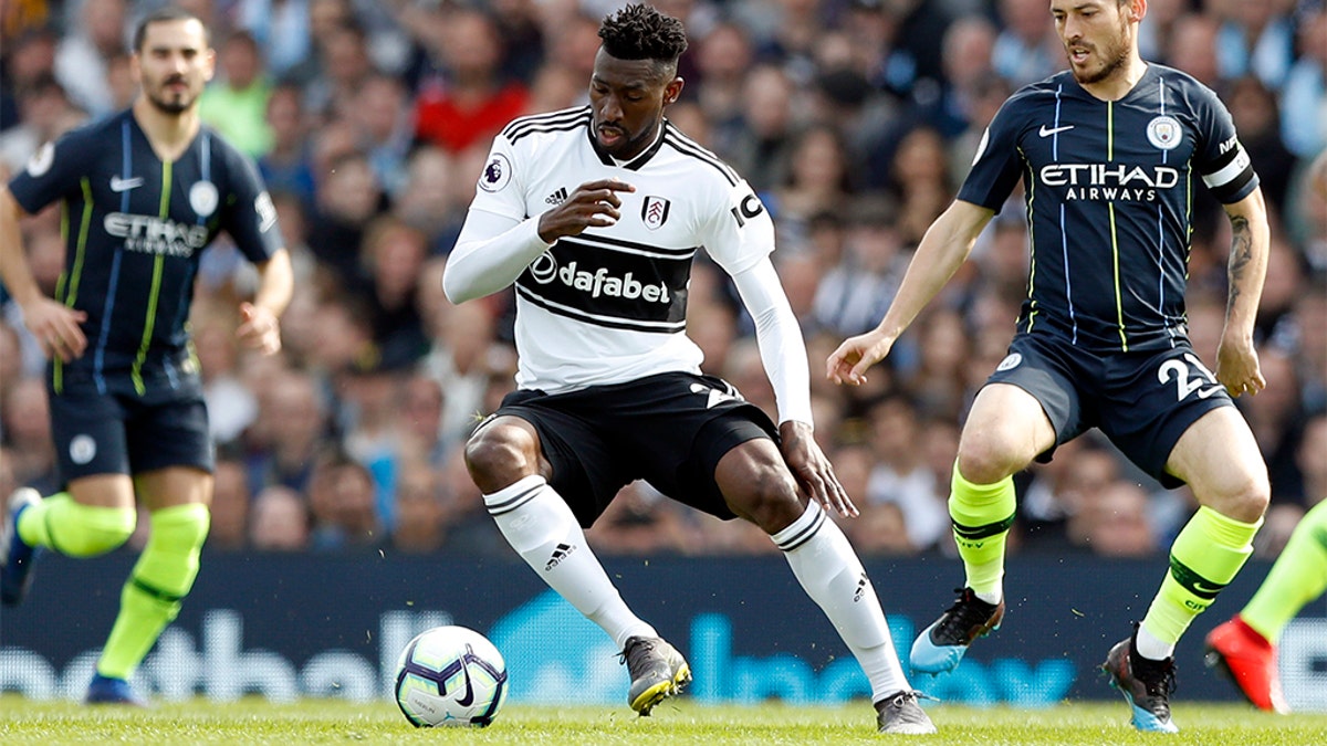 Manchester City's David Silva, right, vies for the ball with Fulham's Andre-Frank Zambo Anguissa during the English Premier League soccer match between Fulham and Manchester City at Craven Cottage stadium in London, Saturday, March 30, 2019. (AP Photo/Alastair Grant)