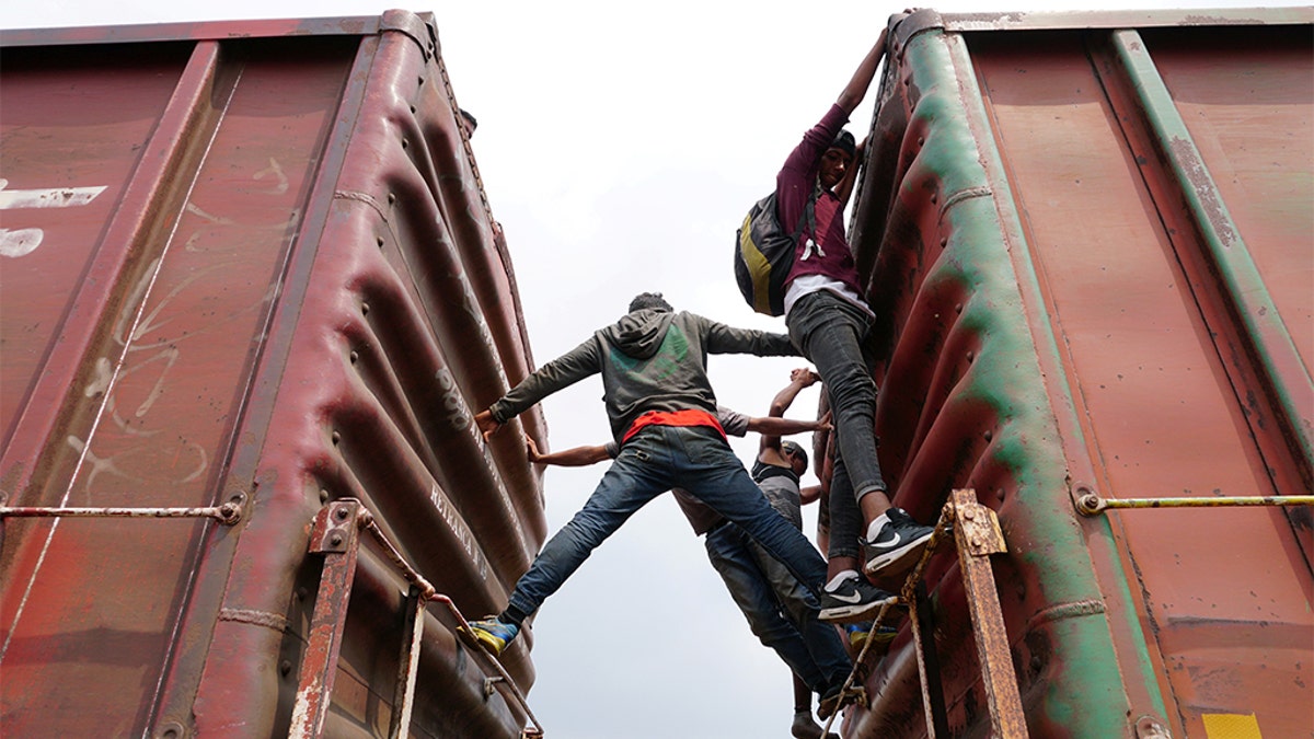 Central American migrants hang on, as they ride a train known as "The Beast", continuing their journey towards the United States, in Ixtepec, Mexico April 26, 2019.
