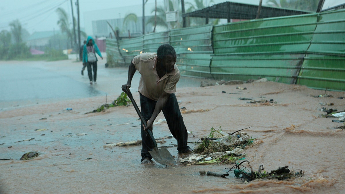 A man clears rubble on a street, in Pemba, on the northeastern coast of Mozambique, Sunday, April, 28, 2019. Serious flooding began on Sunday in parts of northern Mozambique that were hit by Cyclone Kenneth three days ago, with waters waist-high in areas, after the government urged many people to immediately seek higher ground. (AP)