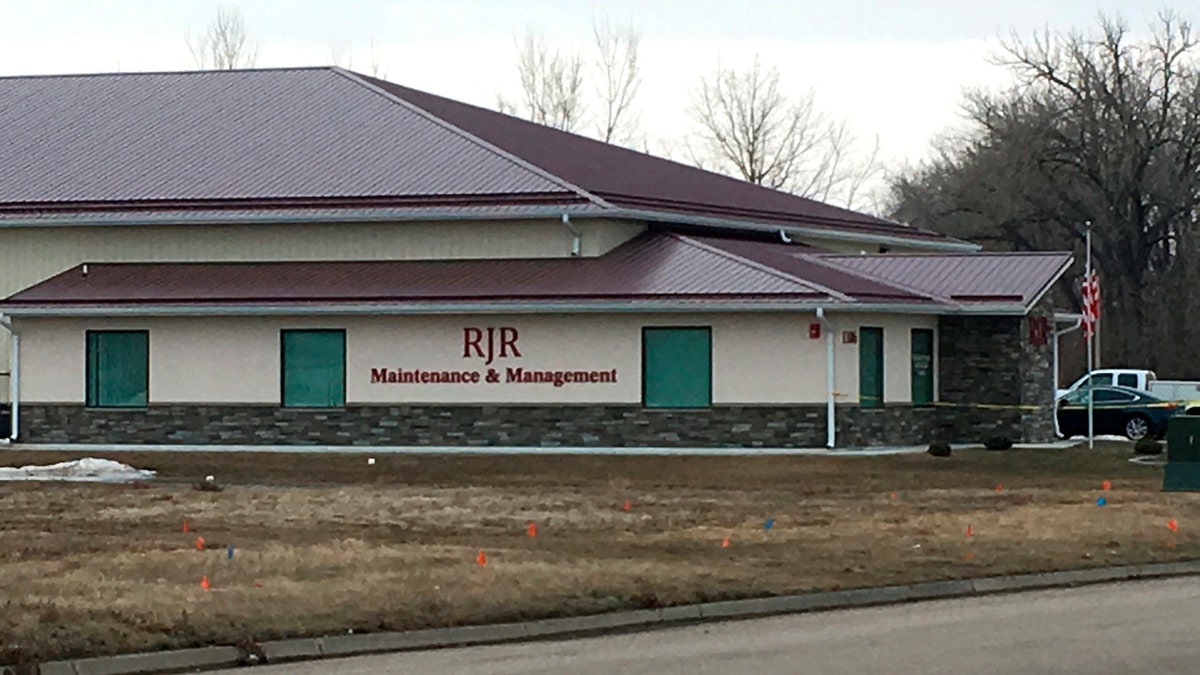 Cars are parked outside RJR Maintenance and Management in Mandan, N.D., on Monday, April 1, 2019. Police in North Dakota said 4 bodies were been found inside the business in suburban Bismarck.