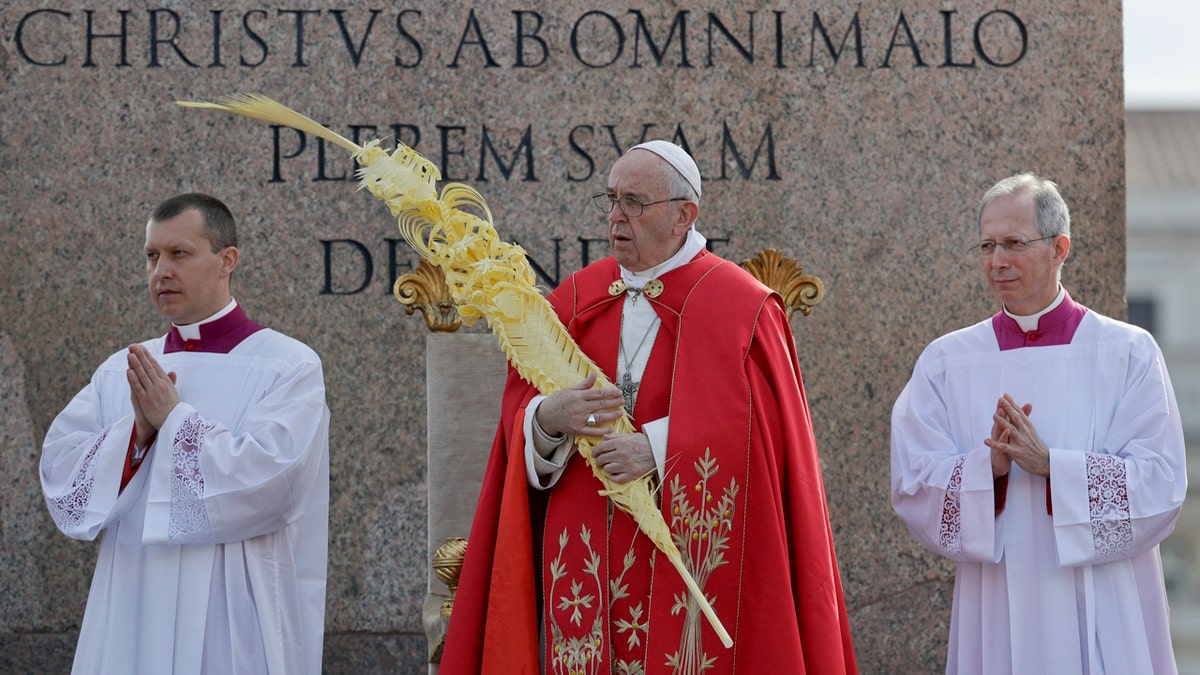 Pope Francis holds a palm frond as he celebrates a Palm Sunday Mass in St. Peter's Square at the Vatican, Sunday, April 14, 2019.