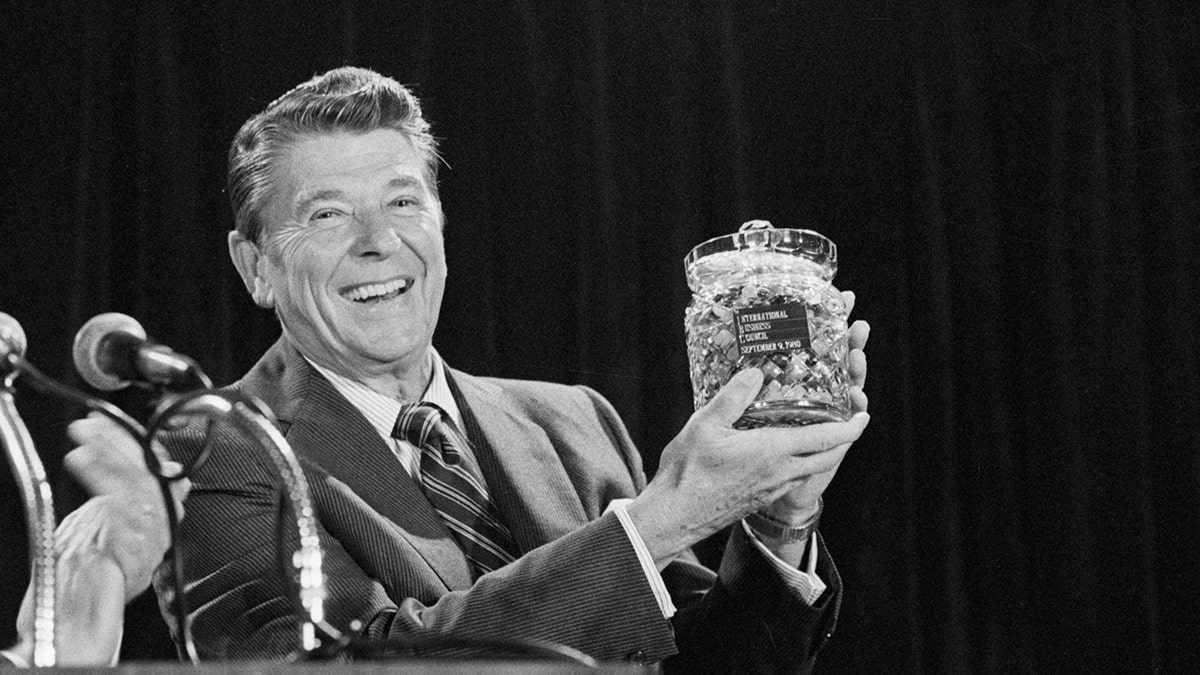 (Original Caption) 9/9/80 - Chicago, Illinois: Republican presidential candidate Ronald Reagan holds a crystal jar of jellybeans presented to him by Clyde Dicky, Jr., president of the International Business Council. (Getty)