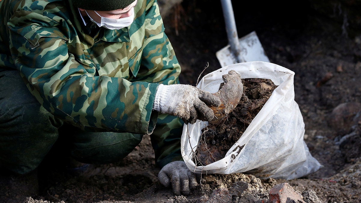 A soldier from a special "search battalion" of Belarus Defence Ministry takes part in the exhumation of a mass grave containing the remains of about 730 prisoners of a former Jewish ghetto, discovered at a construction site in the center of Brest, Belarus February 26, 2019. REUTERS/Vasily Fedosenko - RC1569C86700