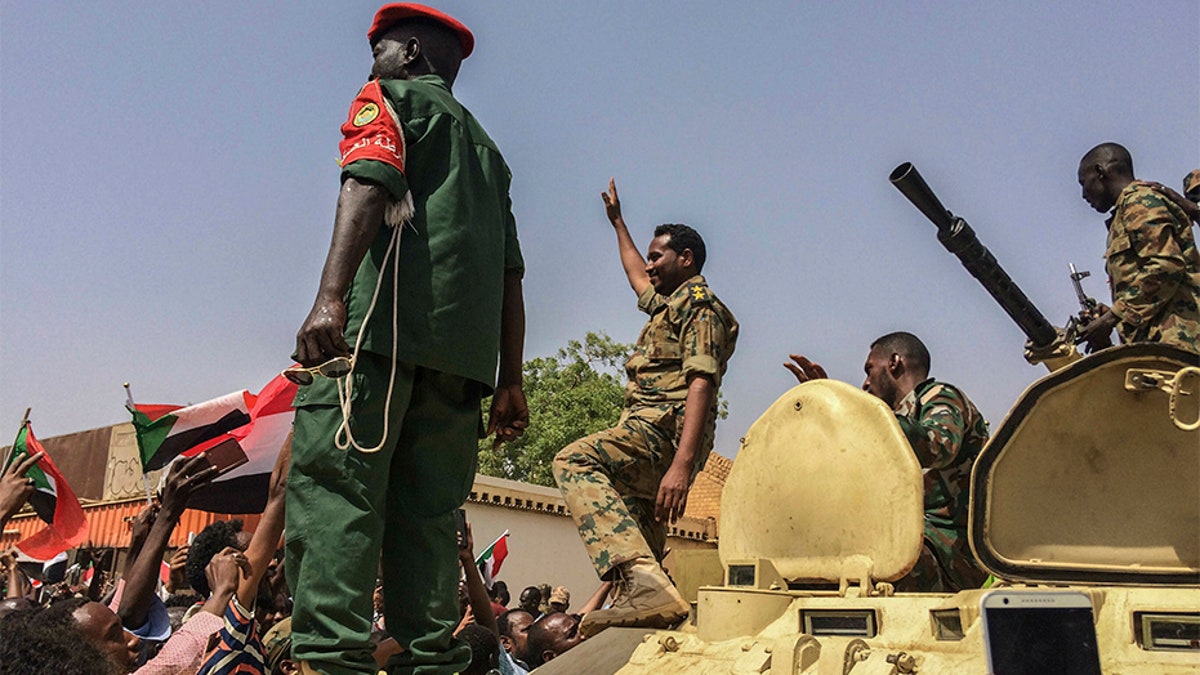 Sudanese forces celebrate on Thursday after officials said the military had forced longtime autocratic President Omar al-Bashir to step down after 30 years in power.