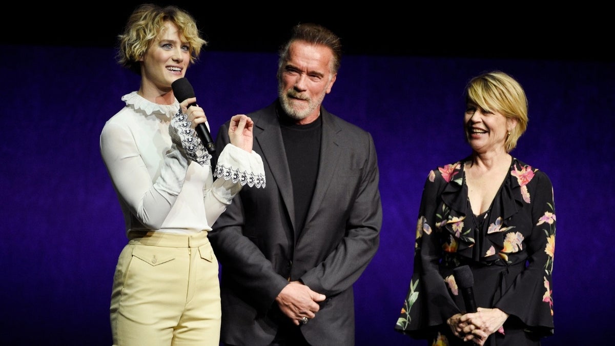 Mackenzie Davis, left, a cast member in the upcoming film "Terminator: Dark Fate," talks about the film as fellow cast members Arnold Schwarzenegger, center, and Linda Hamilton look on.